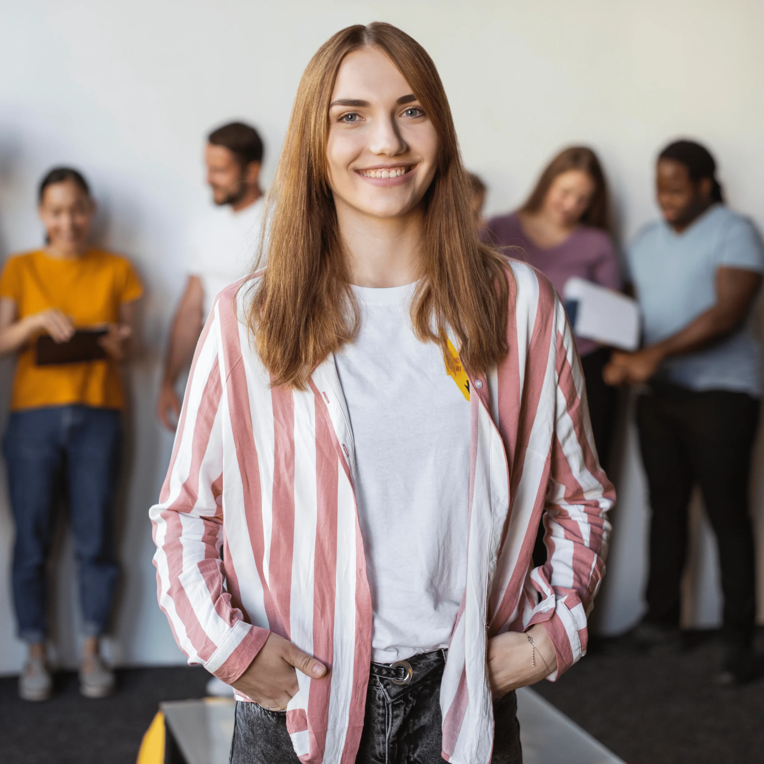Mujer joven con camisa a rayas sonriendo en un entorno profesional.